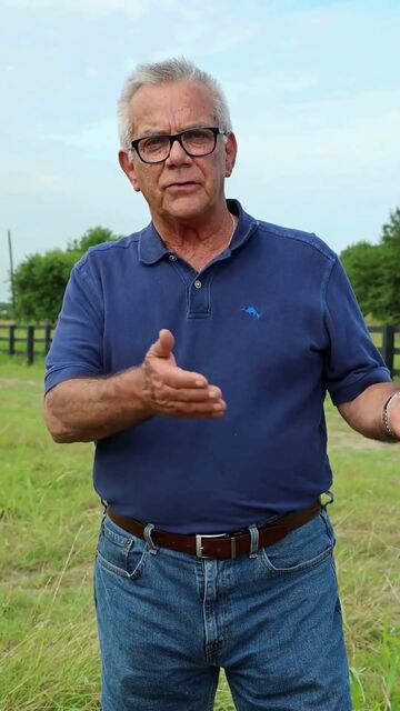 Auctioneer Danny Verdin standing in a fenced Texas pasture explaining how the land auction works